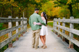 Couple posing on a wooden bridge at Cedar Creek Park during an engagement photography session