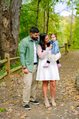 Cedar Creek Park Family Portrait Session 25 Couple posing on a wooden bridge at Cedar Creek Park during an engagement photography session