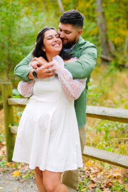 Couple posing on a wooden bridge at Cedar Creek Park during an engagement photography session